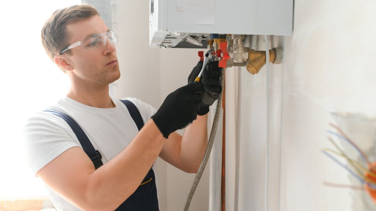 Installateur vervangt een gasketel met de juiste materialen en kledij